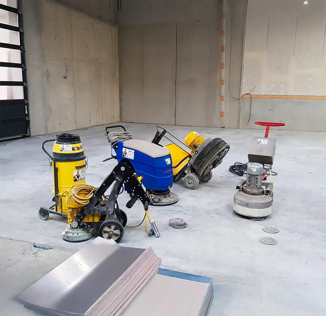 Reinigungs- und Poliermaschinen auf einem Betonboden in einer leeren Halle