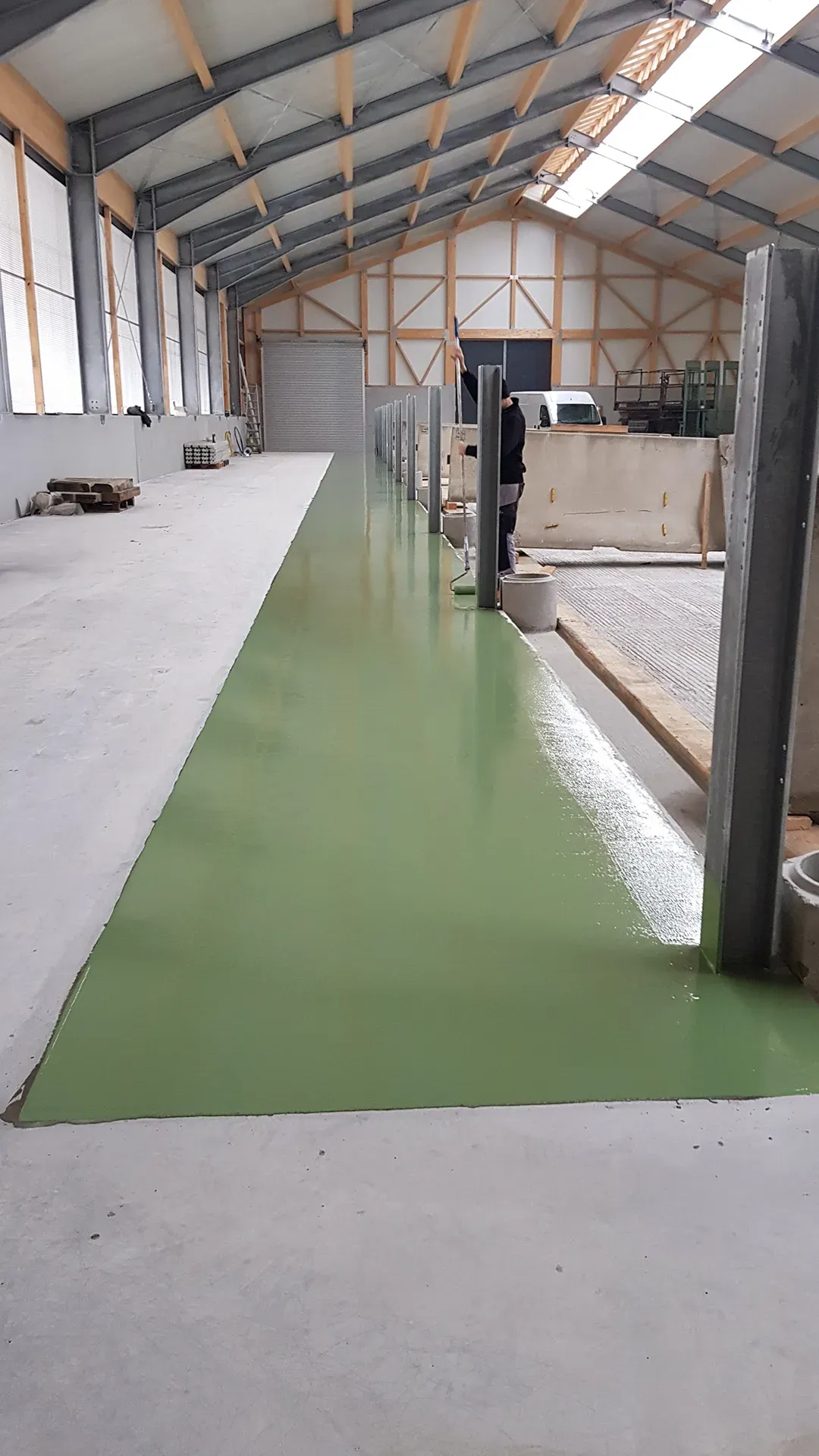 grüne Bodenversiegelung in einer Halle mit Metall- und Holzkonstruktionen