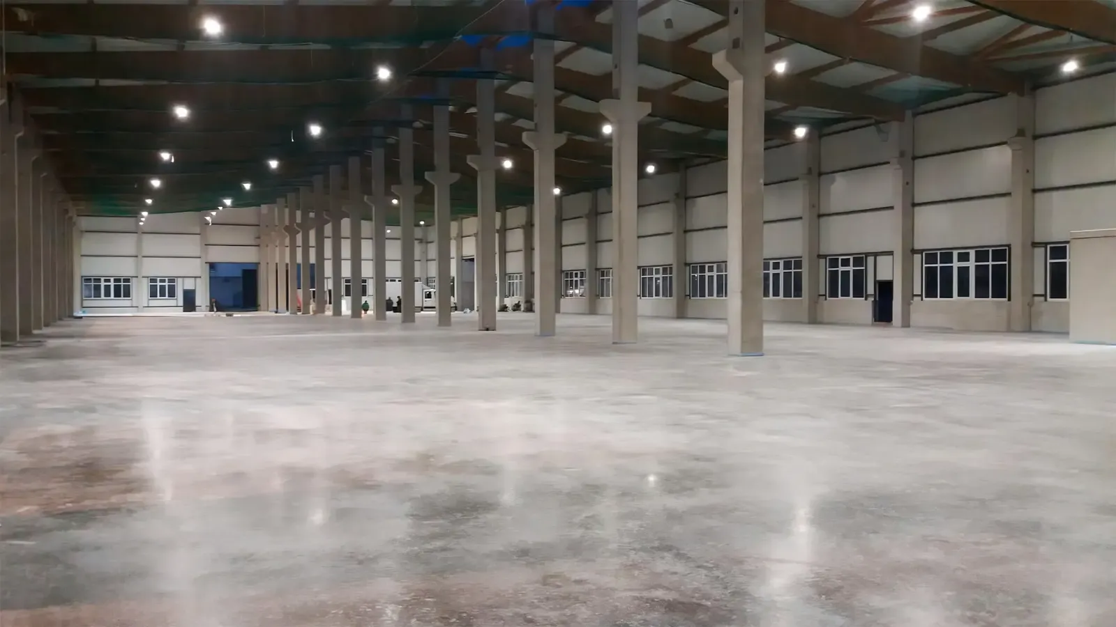 große Lagerhalle mit hohen Betonstützen und poliertem Betonboden