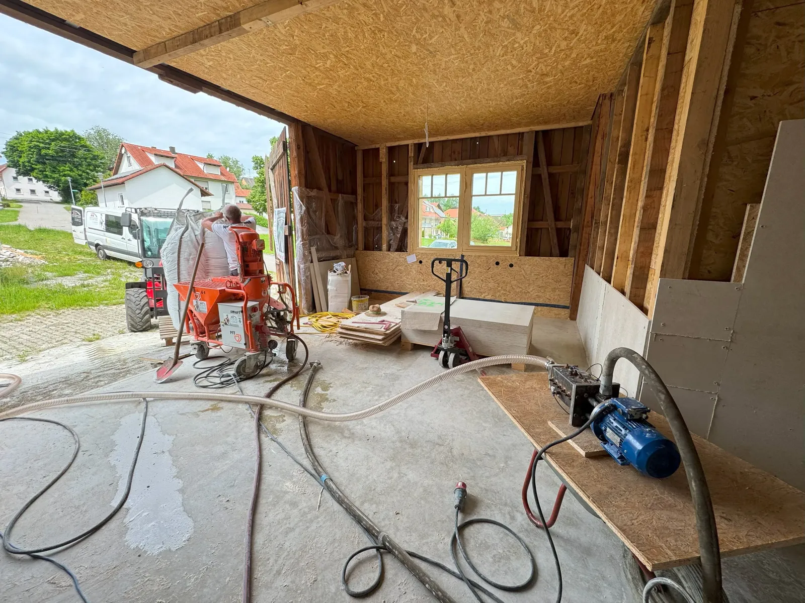 Dämmstoffanlage in einer offenen Holzkonstruktion mit verschiedenen Werkzeugen und Materialien