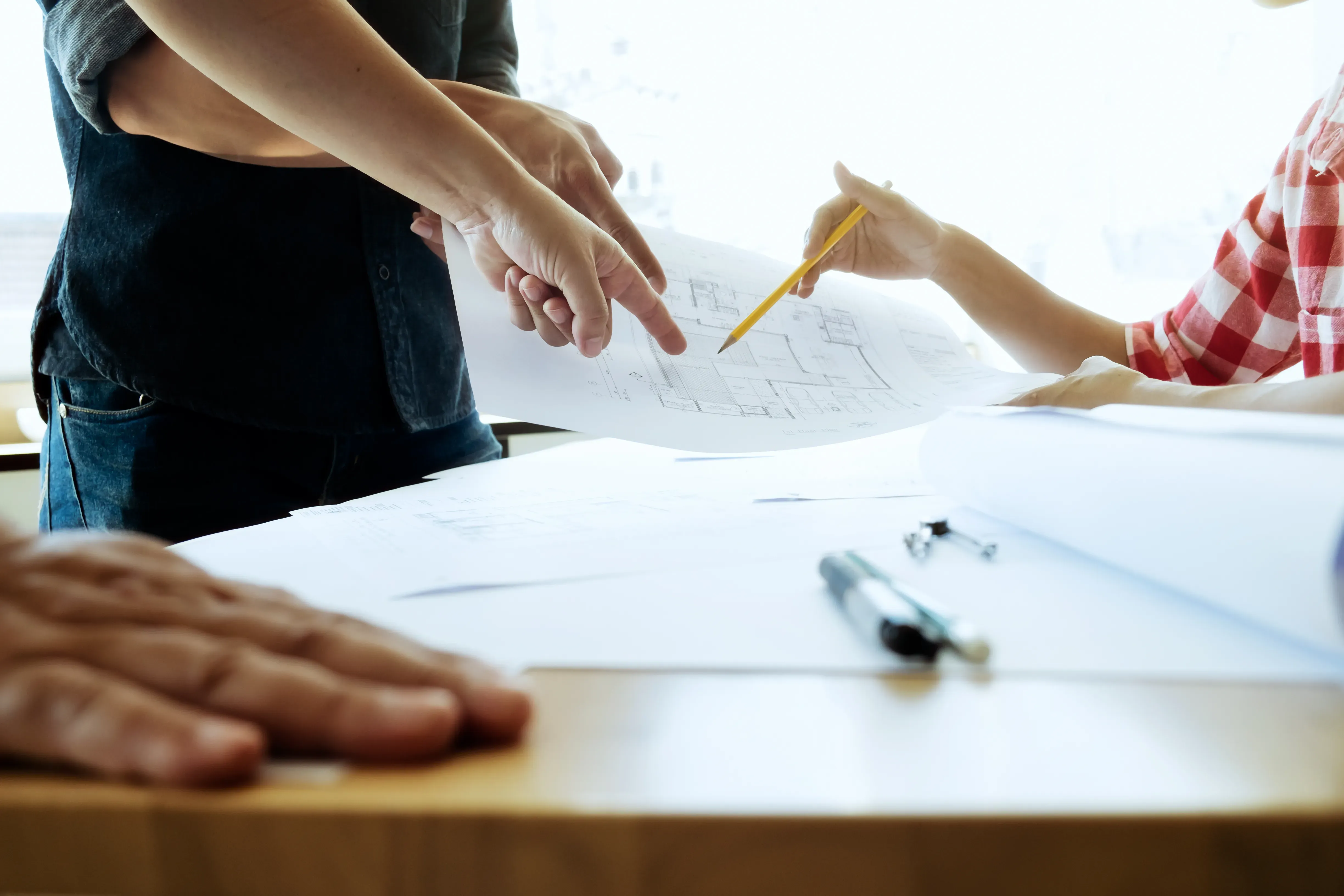 Architekten und Planer diskutieren Baupläne an einem hell beleuchteten Tisch